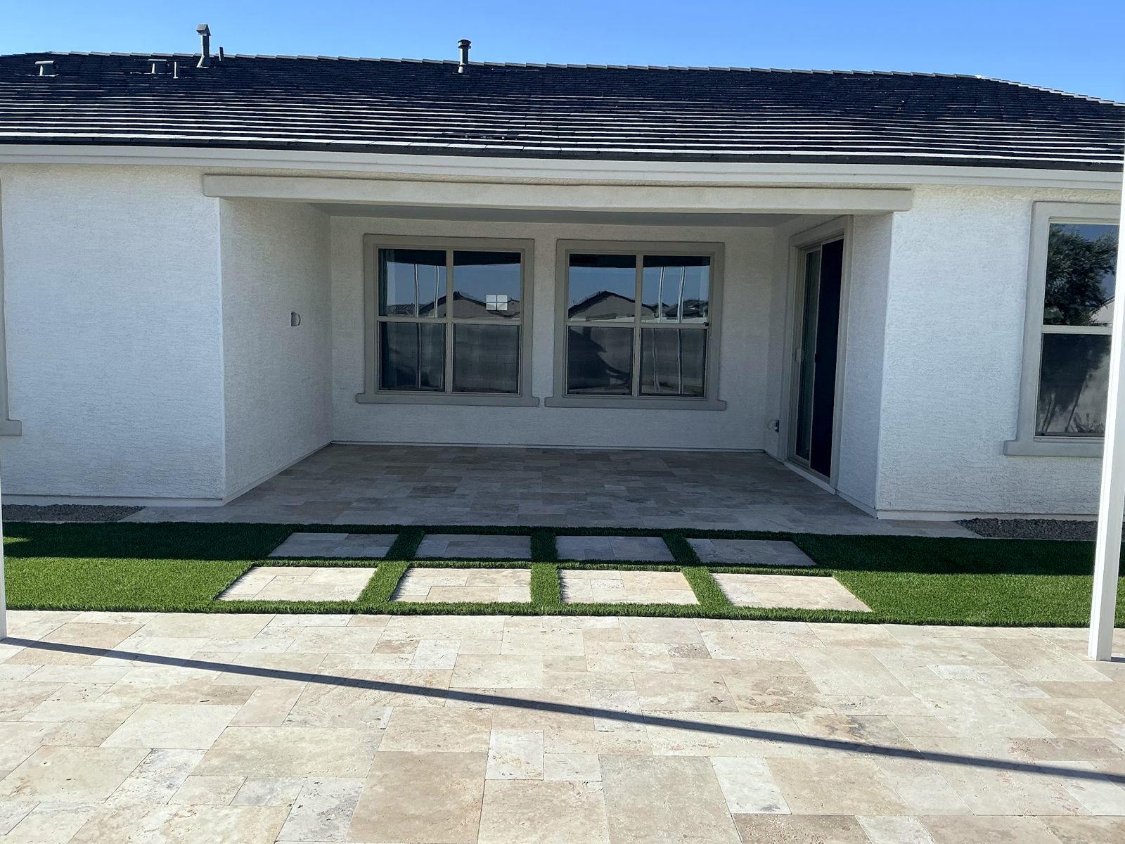 Travertine patio with travertine stepping pads in turf