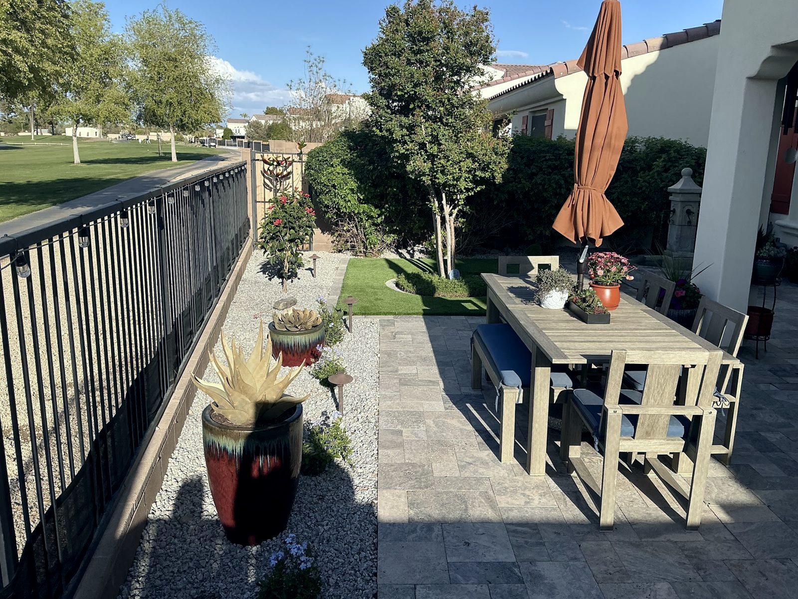 Travertine dining patio beside desert planting