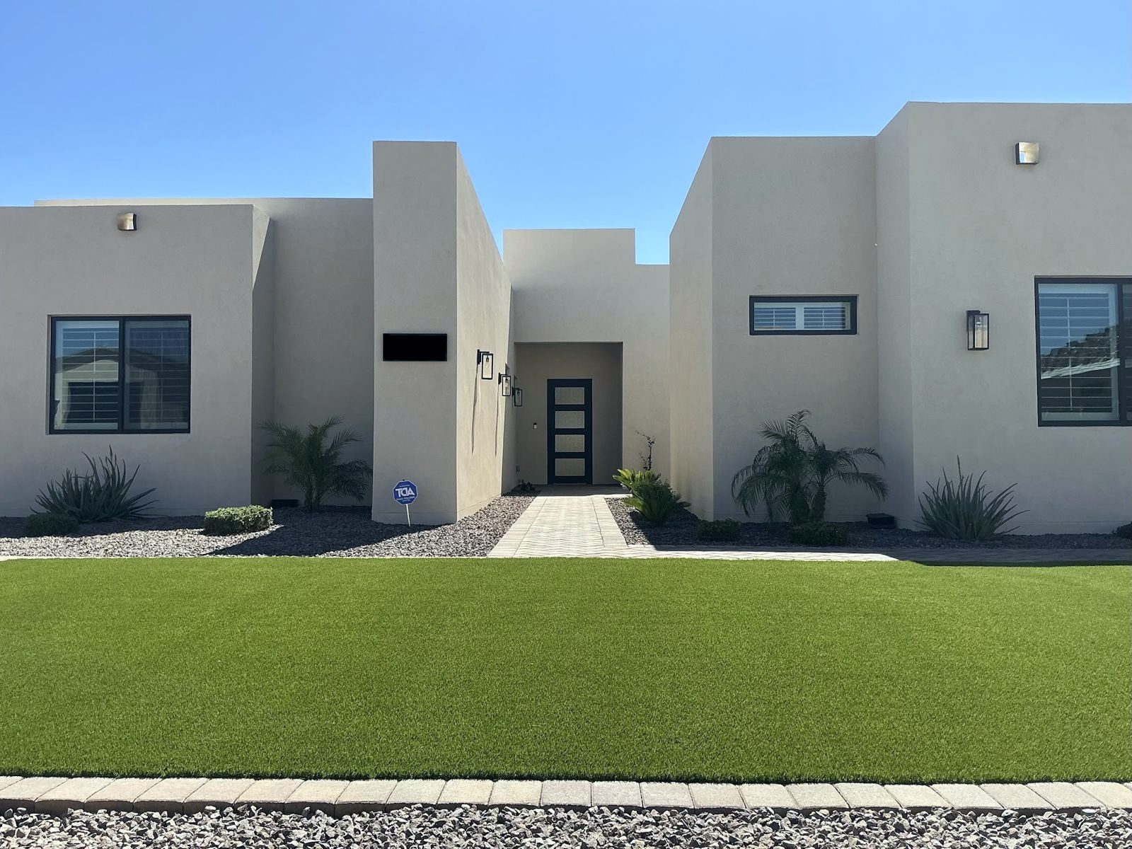 Modern front yard with a full turf lawn and paver border