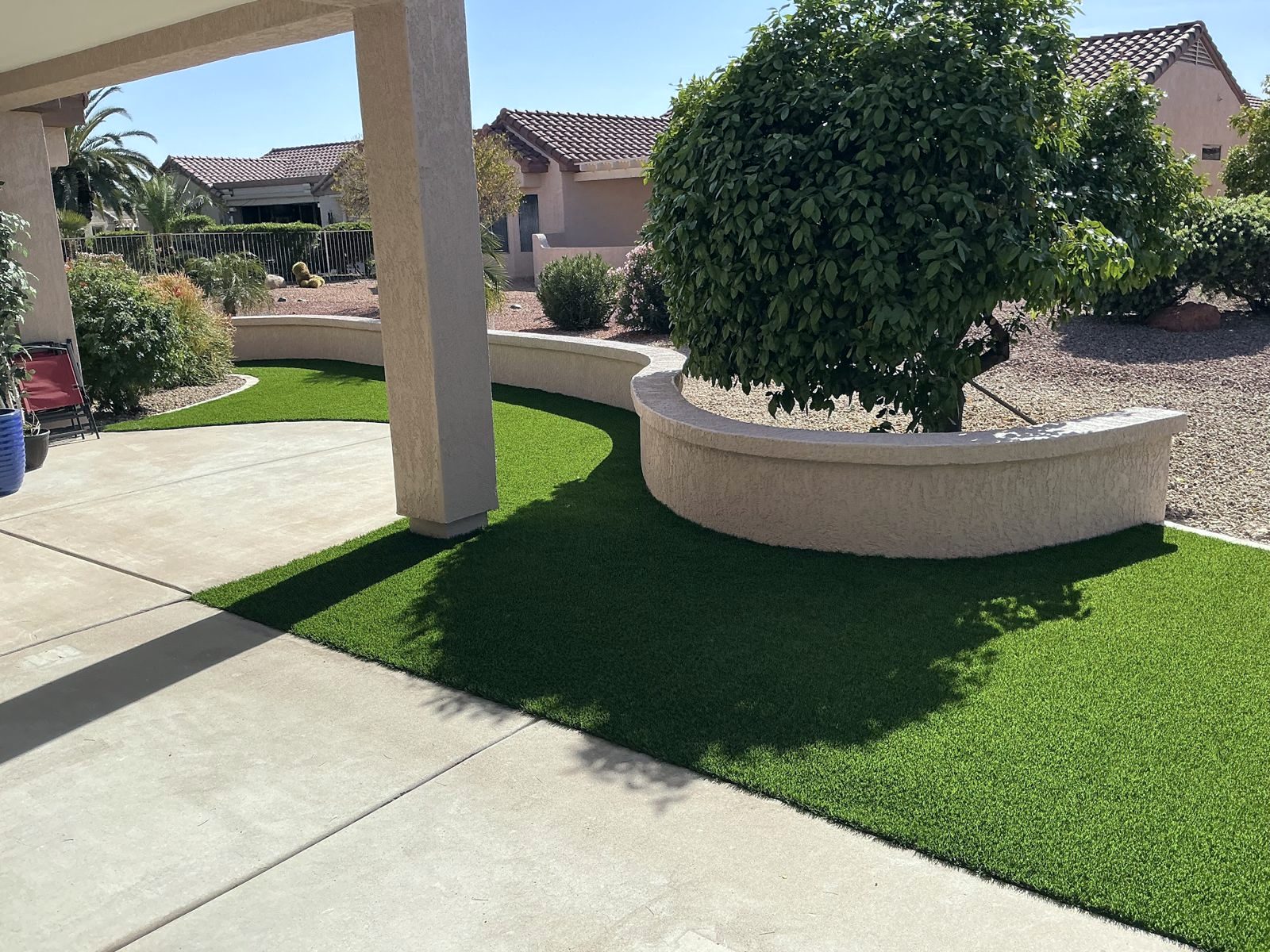 Curved turf lawn wrapping a planter wall by the patio